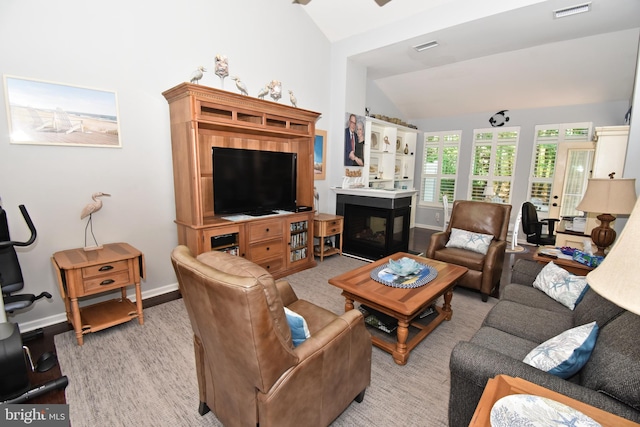 living room featuring a multi sided fireplace, visible vents, baseboards, and lofted ceiling