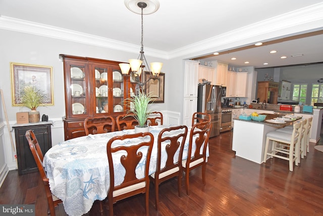 dining space with a notable chandelier, recessed lighting, ornamental molding, dark wood finished floors, and wainscoting