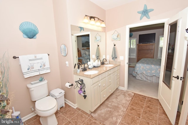 bathroom with toilet, tile patterned floors, connected bathroom, and a sink