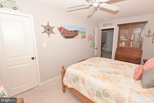 bedroom with a ceiling fan, baseboards, and light colored carpet