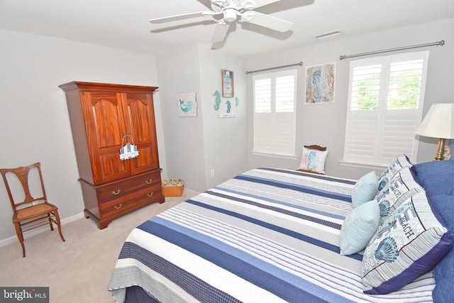 bedroom with a ceiling fan, light carpet, visible vents, and baseboards