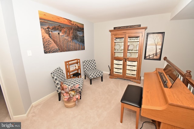 living area with baseboards and carpet