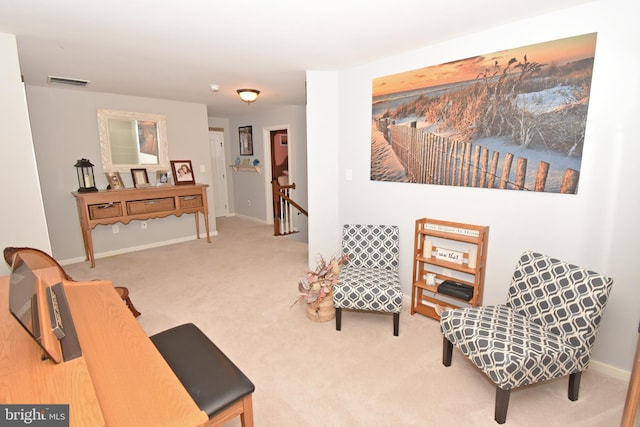 living area featuring visible vents, an upstairs landing, baseboards, and carpet floors
