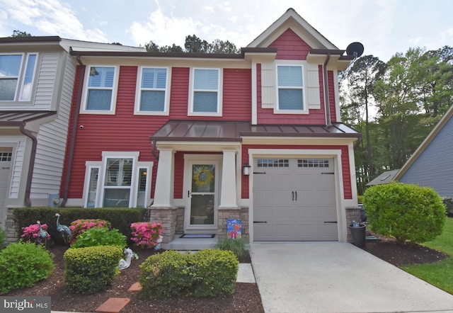 townhome / multi-family property featuring metal roof, concrete driveway, a garage, and a standing seam roof