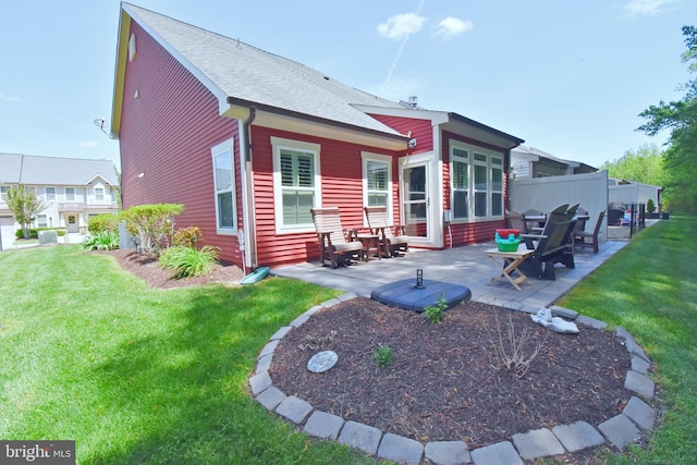 back of property featuring a yard, fence, a patio, and a shingled roof