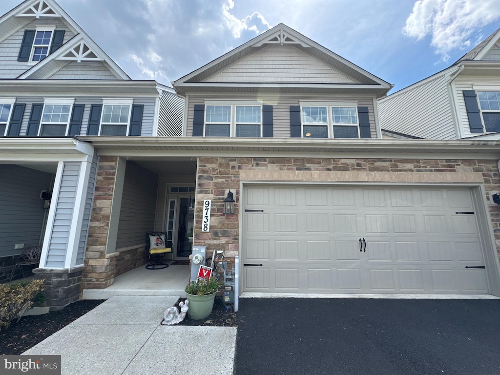 view of front facade featuring aphalt driveway and stone siding