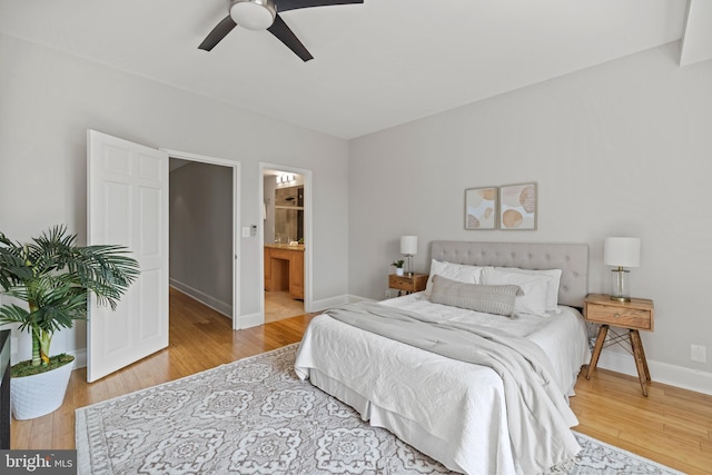 bedroom with baseboards, connected bathroom, ceiling fan, and wood finished floors