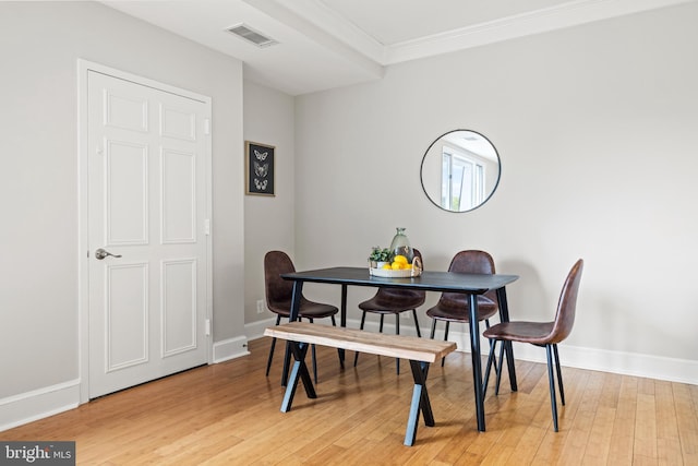 dining space with crown molding, baseboards, visible vents, and light wood-type flooring