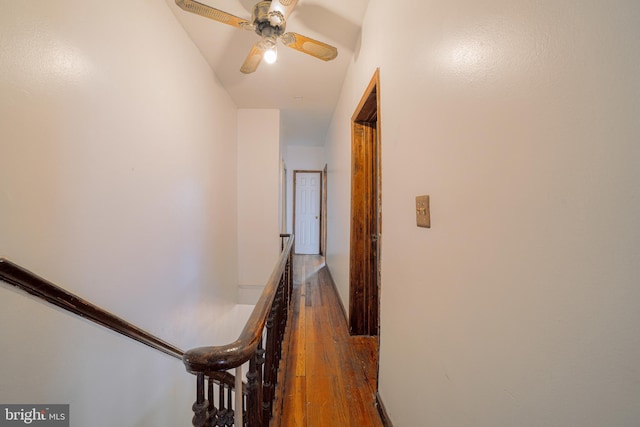 hall with dark wood-style floors and an upstairs landing
