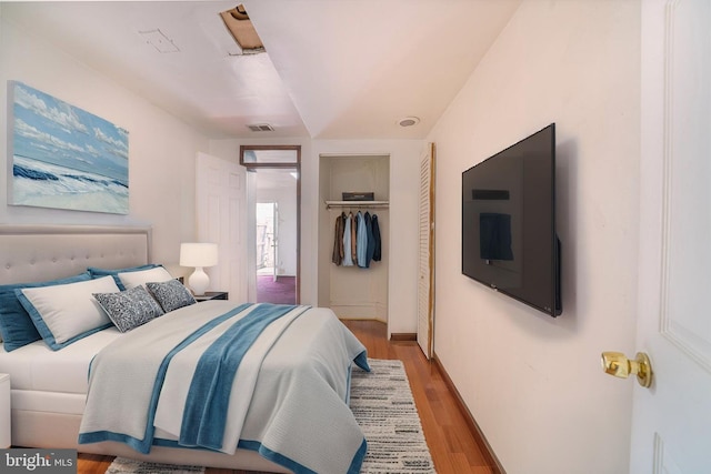 bedroom featuring a closet, wood finished floors, and baseboards