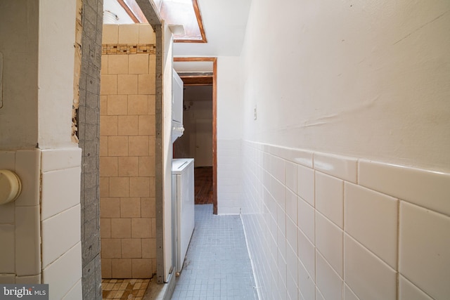bathroom featuring tile walls, tile patterned floors, and a wainscoted wall