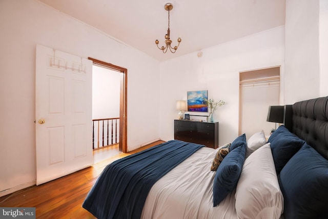 bedroom featuring wood finished floors and a chandelier