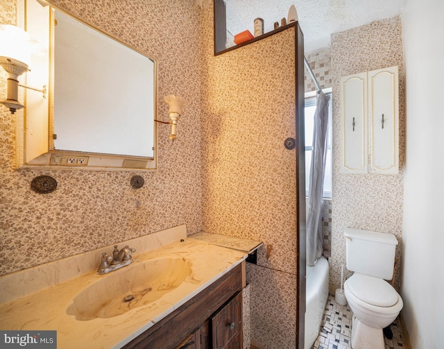bathroom featuring vanity, shower / bath combo with shower curtain, and toilet