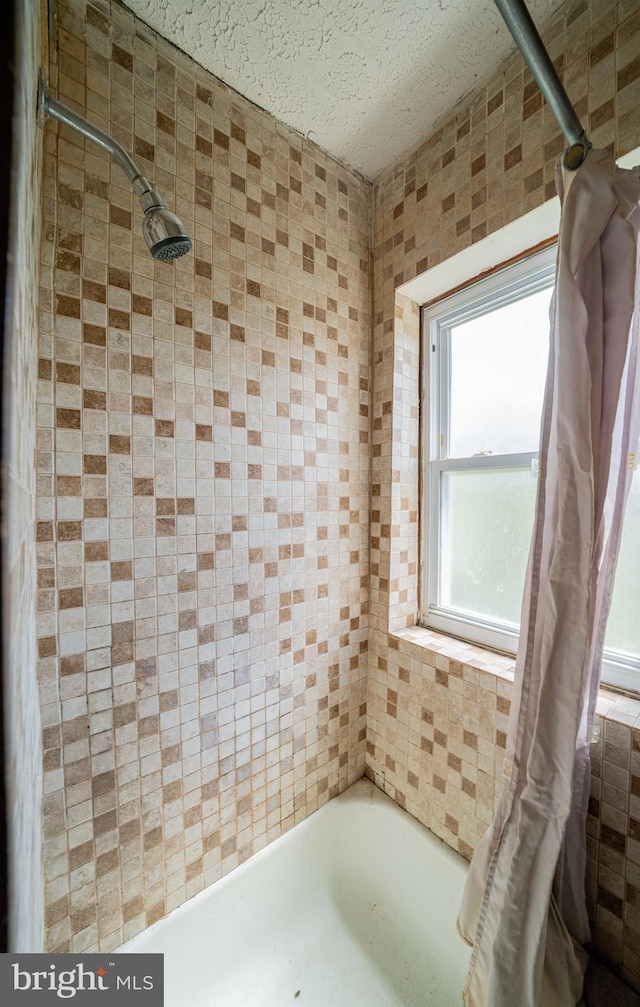 full bath with a shower with curtain and a textured ceiling