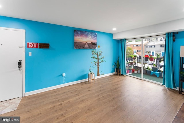 empty room with recessed lighting, baseboards, and wood finished floors
