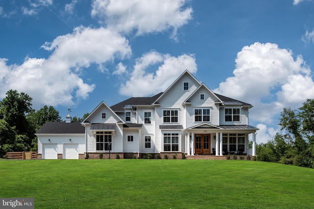 view of front facade with a standing seam roof, an attached garage, a porch, and a front lawn