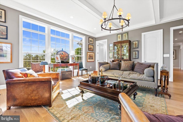 living area with an inviting chandelier, baseboards, beam ceiling, and wood finished floors