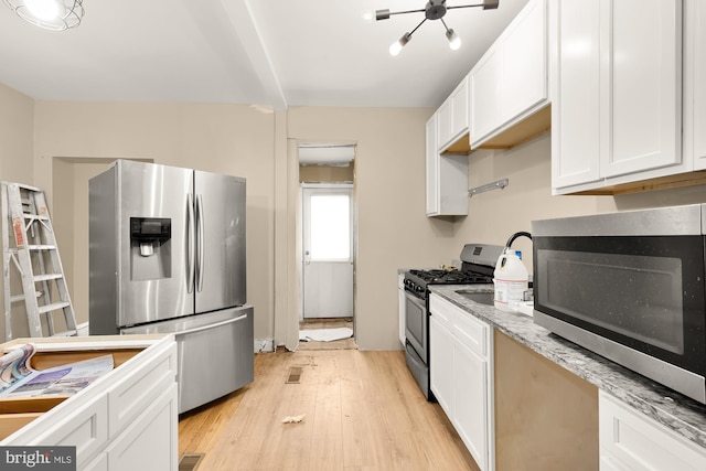 1222 18th St NE, Washington, DC 20002 - kitchen with light wood-type flooring, appliances with stainless steel finishes, light stone counters, and white cabinets