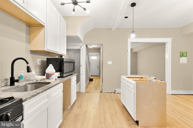 1222 18th St NE, Washington, DC 20002 - kitchen with white cabinets, stainless steel microwave, a sink, and light wood-type flooring