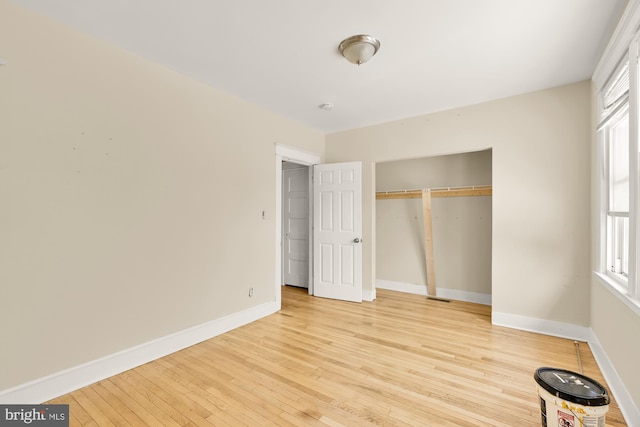 1222 18th St NE, Washington, DC 20002 - unfurnished bedroom with light wood-type flooring, baseboards, a closet, and multiple windows