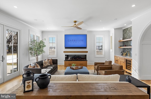 76 Filly Ln, Lewes, DE 19958 - living area with wine cooler, bar area, crown molding, light wood finished floors, and a ceiling fan