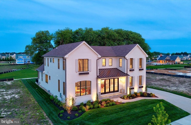 76 Filly Ln, Lewes, DE 19958 - view of front of home featuring a standing seam roof, a lawn, and metal roof