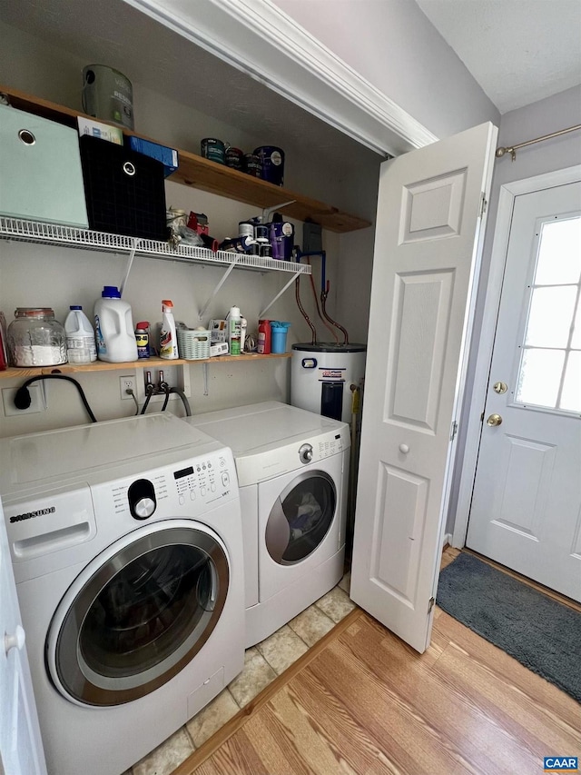 laundry room with laundry area, water heater, and independent washer and dryer