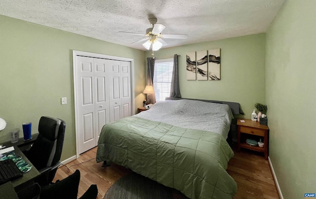 bedroom featuring baseboards, ceiling fan, a closet, and wood finished floors