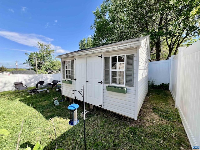 view of outbuilding with a fenced backyard and an outbuilding