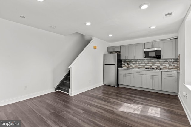kitchen featuring gray cabinetry, appliances with stainless steel finishes, dark wood-type flooring, and visible vents
