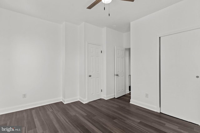 unfurnished bedroom with a closet, baseboards, a ceiling fan, and dark wood finished floors