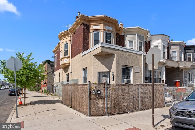view of property with a fenced front yard, a residential view, and cooling unit