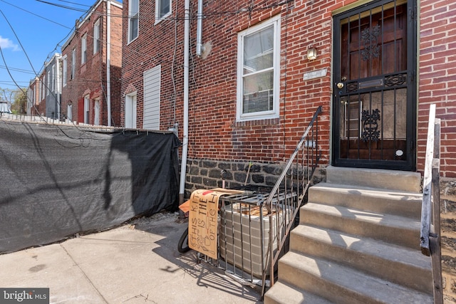 view of exterior entry with brick siding