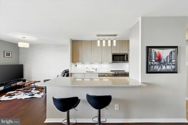 9701 Fields Rd Unit 2301, Gaithersburg, MD 20878 - kitchen featuring appliances with stainless steel finishes, track lighting, dark wood finished floors, a breakfast bar, and a sink