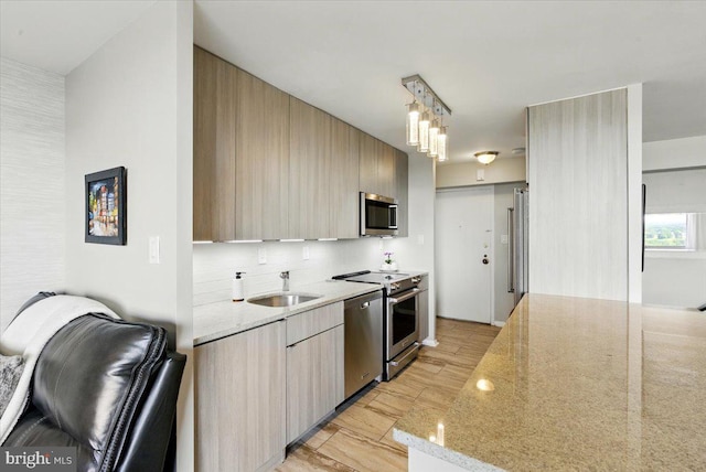 9701 Fields Rd Unit 2301, Gaithersburg, MD 20878 - kitchen featuring appliances with stainless steel finishes, a sink, light stone counters, modern cabinets, and tasteful backsplash