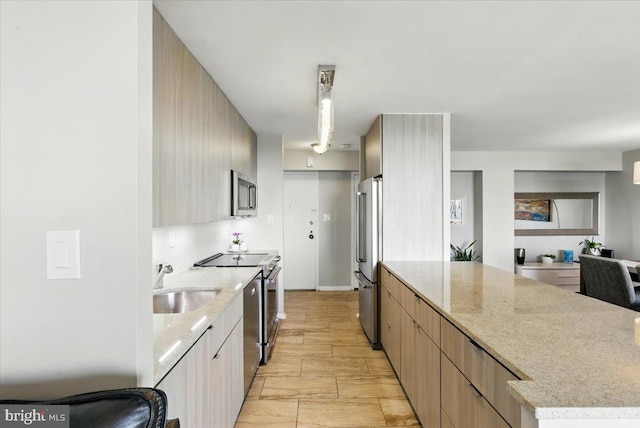 9701 Fields Rd Unit 2301, Gaithersburg, MD 20878 - kitchen featuring stainless steel appliances, a sink, modern cabinets, light stone countertops, and a peninsula