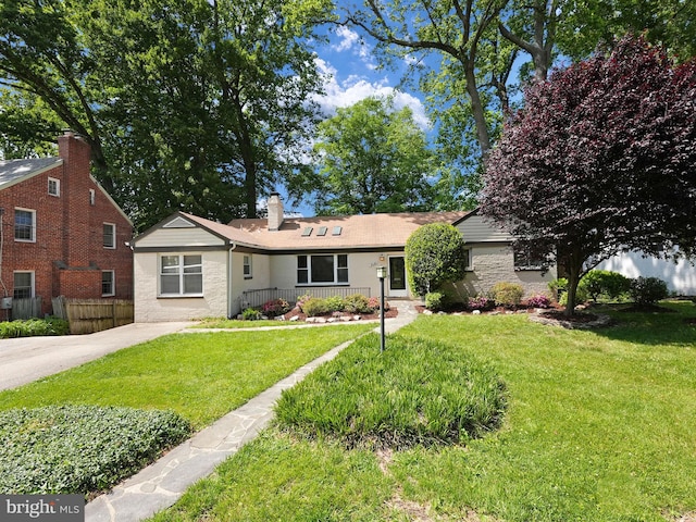 view of front of home with fence, a chimney, and a front lawn