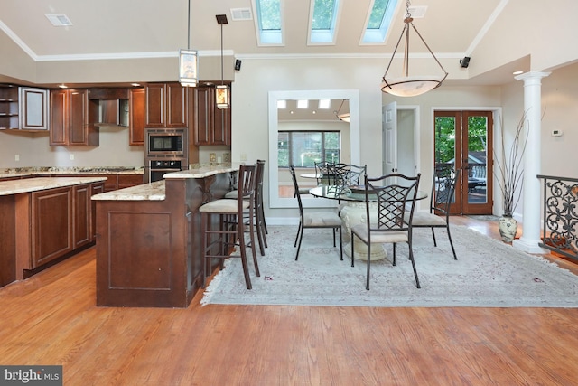 dining area featuring visible vents, ornamental molding, vaulted ceiling, and light wood-type flooring