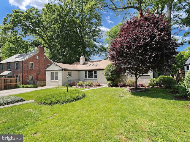 view of front of home featuring a front lawn and fence