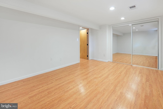 unfurnished bedroom featuring visible vents, a closet, light wood-style floors, baseboards, and recessed lighting