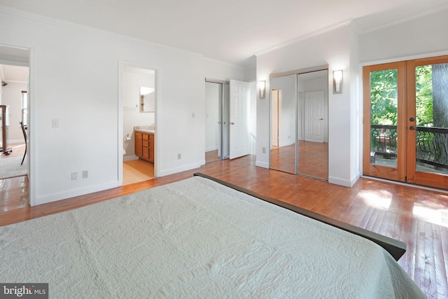 unfurnished bedroom with crown molding, wood finished floors, access to exterior, baseboards, and french doors