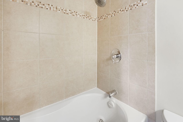 bathroom featuring bathing tub / shower combination and toilet