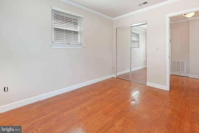 unfurnished bedroom with baseboards, visible vents, ornamental molding, and a closet