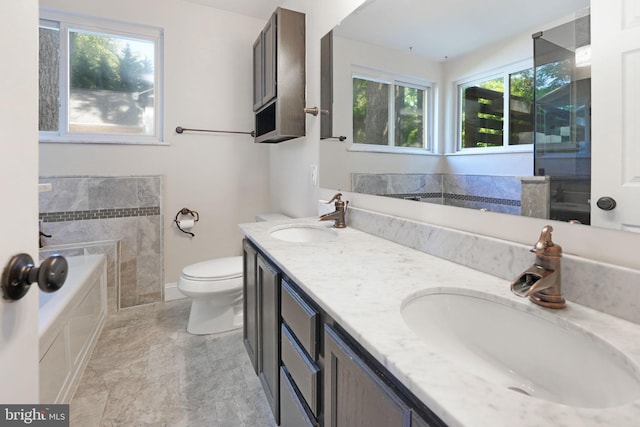 full bath featuring double vanity, toilet, a sink, and a garden tub