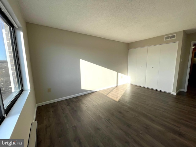 200 N Pickett St Unit 1412, Alexandria, VA 22304 - unfurnished bedroom with dark wood-style flooring, a textured ceiling, visible vents, baseboards, and a closet