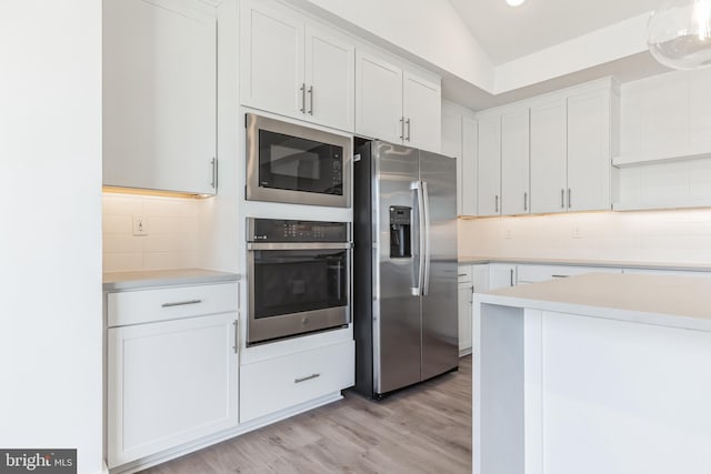 kitchen with light countertops, appliances with stainless steel finishes, and tasteful backsplash