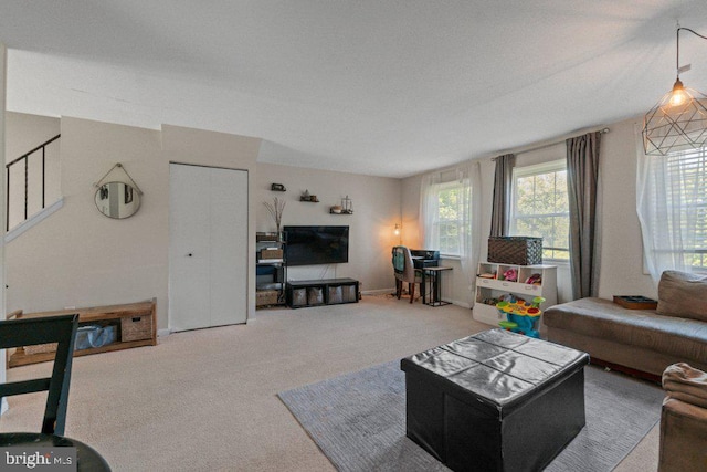 carpeted living room with stairs