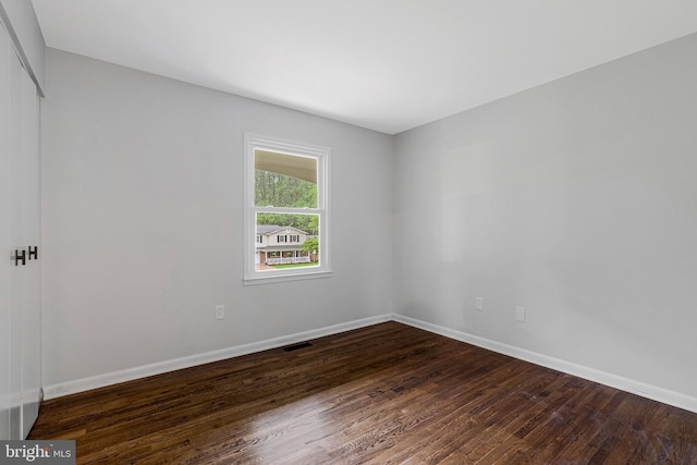 unfurnished room featuring dark wood finished floors and baseboards