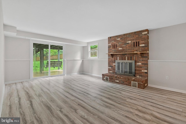 unfurnished living room featuring wood finished floors, a fireplace, and baseboards