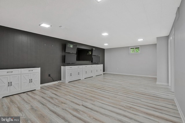unfurnished living room featuring light wood-type flooring and baseboards
